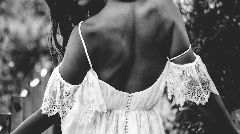 grayscale photo of woman wearing cold-shoulder backless dress